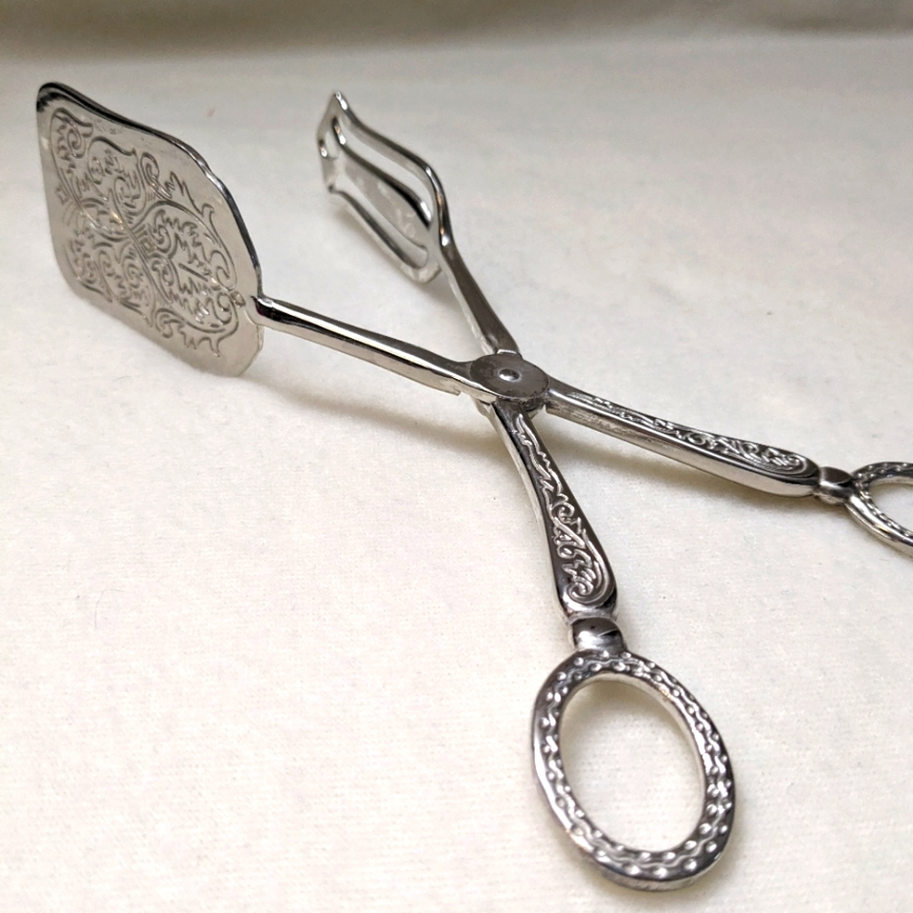 Stunning silver colored etched salad tongs.